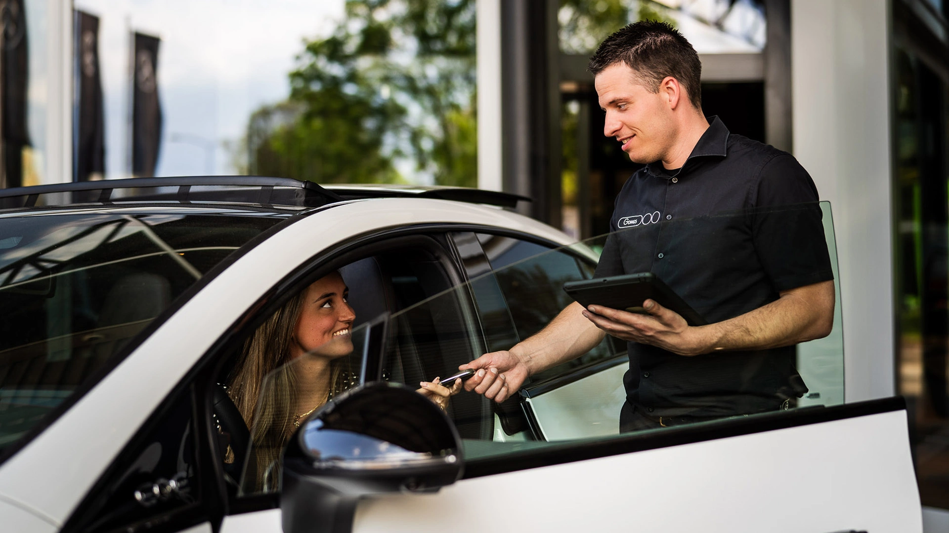 Gomes collega neemt de auto van een klant aan voor een afspraak voor onderhoud