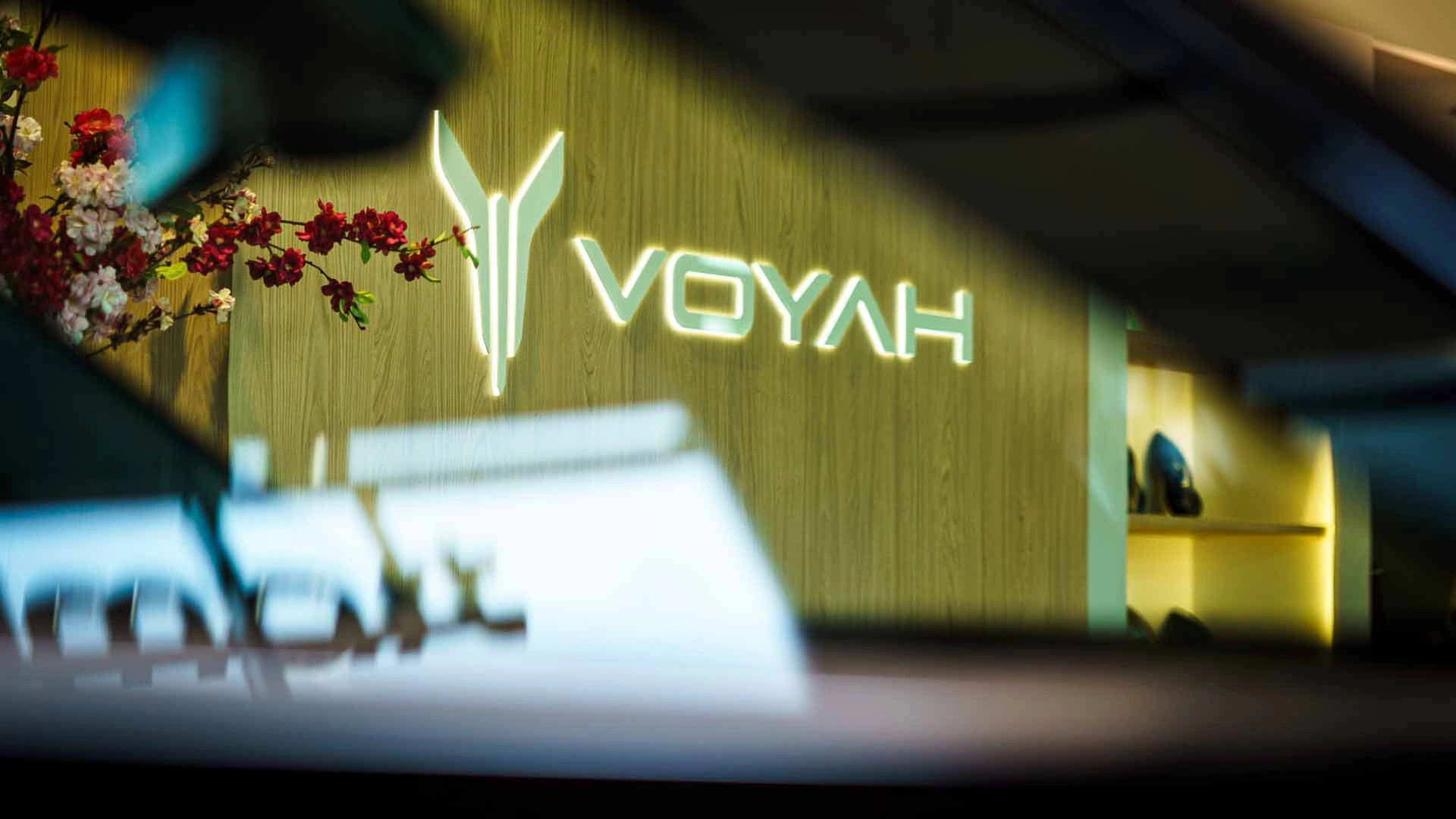 Detailfoto van het VOYAH logo in de showroom bij Gomes