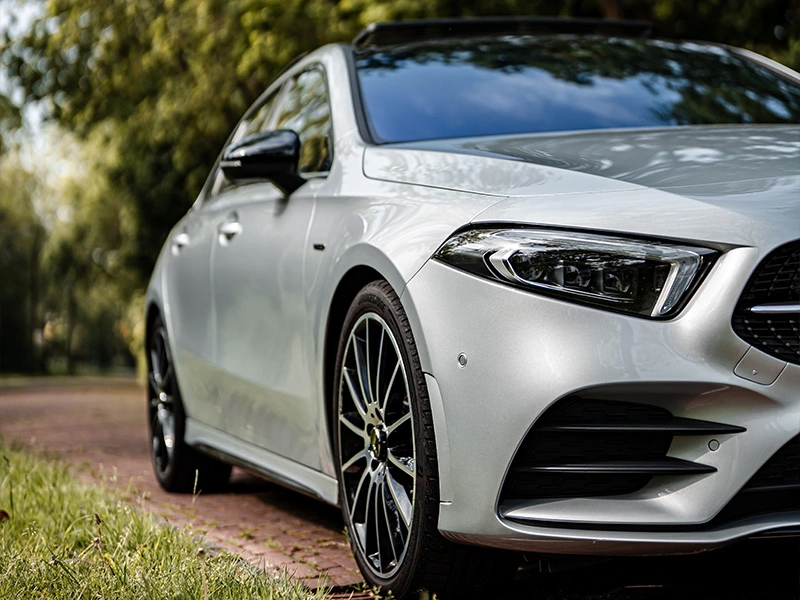 Foto van het voor zijaanzicht van een Mercedes-Benz A-Klasse Hatchback en de koplamp met DYNAMIC select