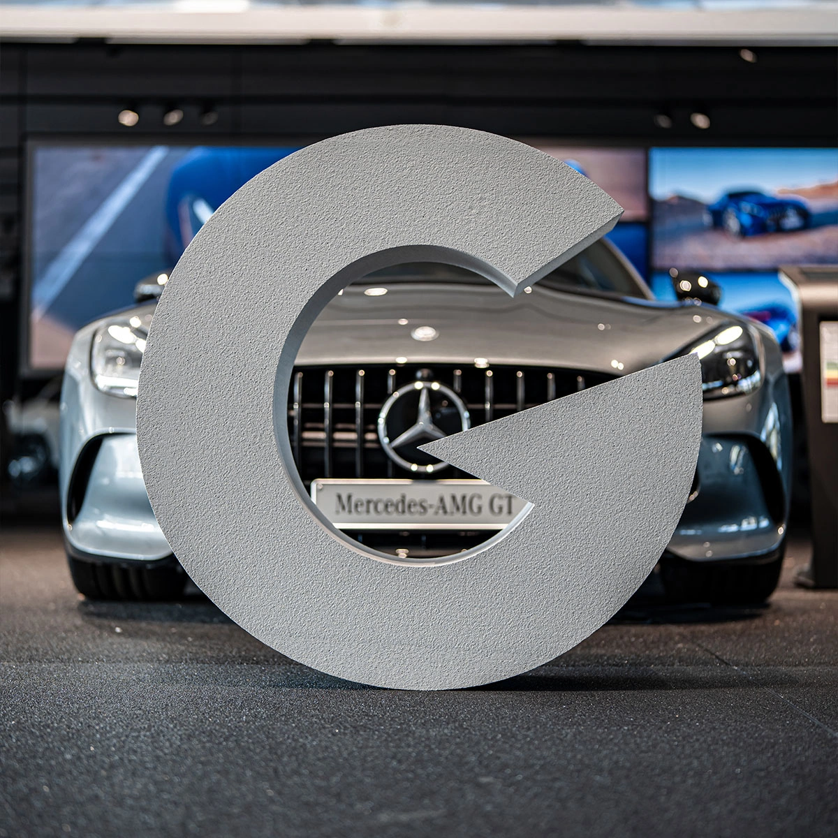 Foto in de showroom van Gomes met een Mercedes-Benz personenwagen op de voorgrond